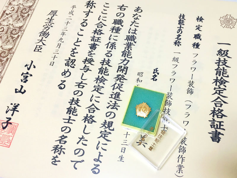 合格証書と金色の技能士バッチ